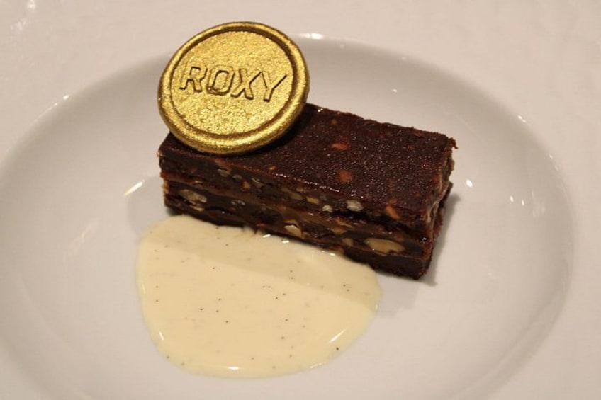 A dessert with a gold seal labeled 'ROXY' on a white plate. 2
