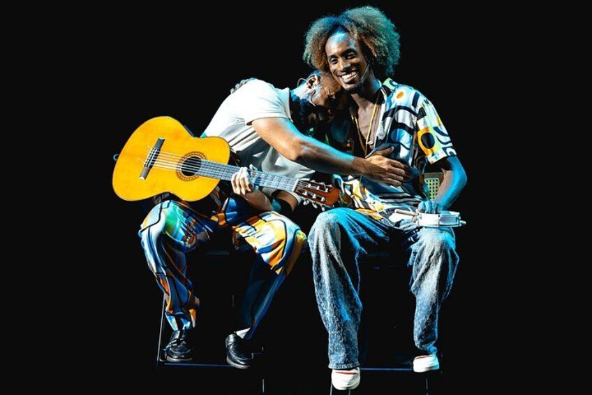Two people sitting on a stool, one holding a guitar. 3