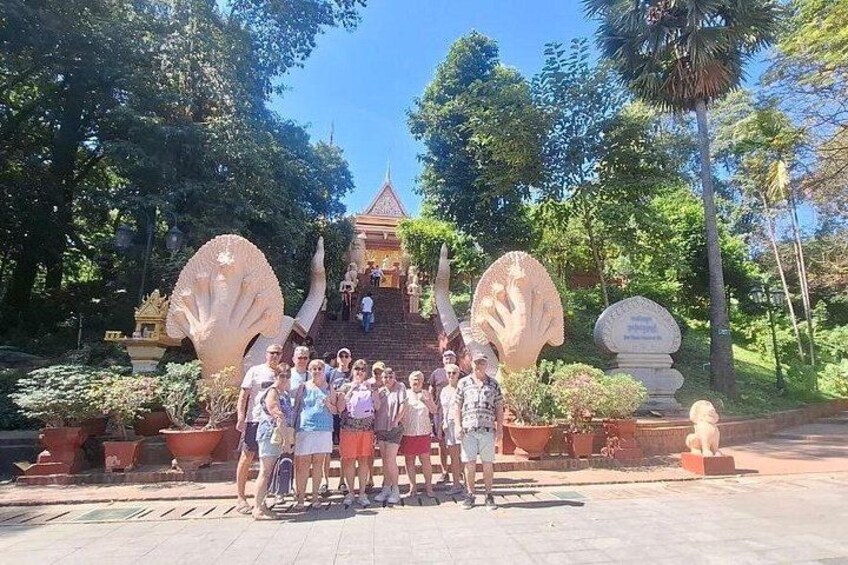 A group of people posing in front of a temple with large decorative shells and a statue. 1