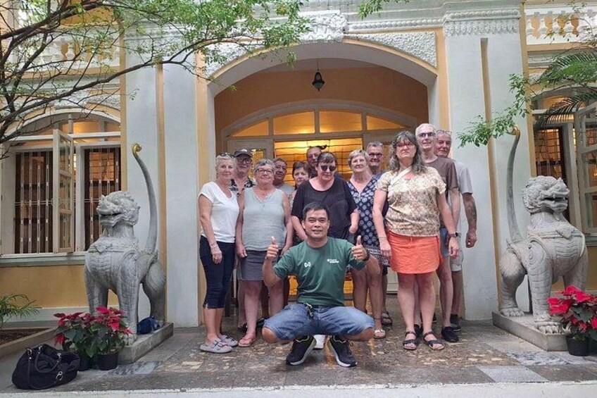 A group of people posing in front of a building with a decorative entrance and two lion statues on either side. 5