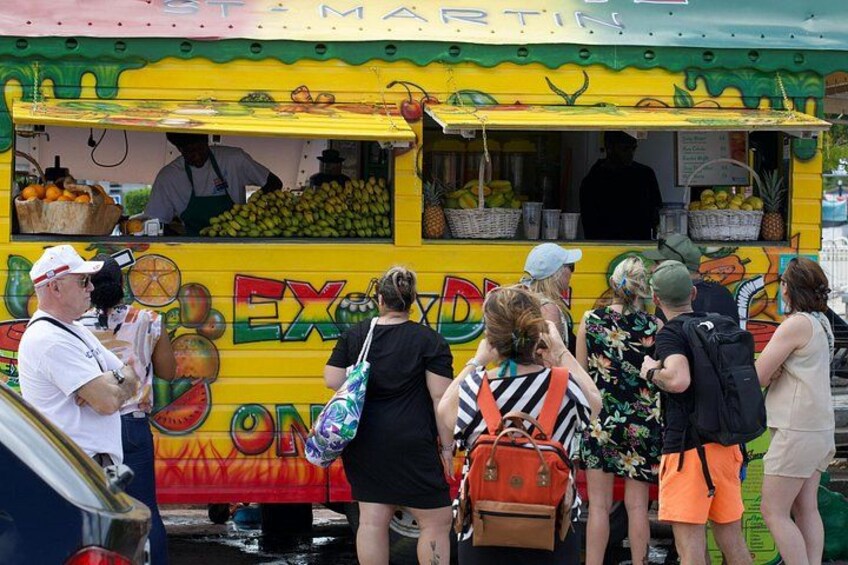 Un camión de comida colorido con temática tropical, que incluye ilustraciones de frutas y un letrero que dice 'EXOZON'. 4
