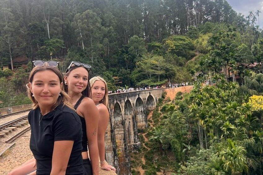 Un puente con arcos góticos, rodeado de exuberante vegetación tropical. 2