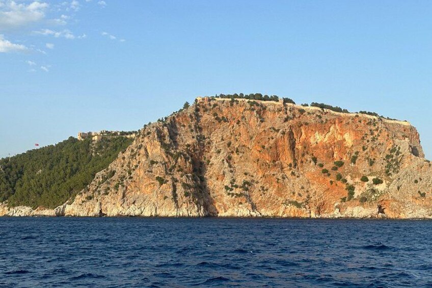 A coastal cliff with a small settlement on top, surrounded by water. 2