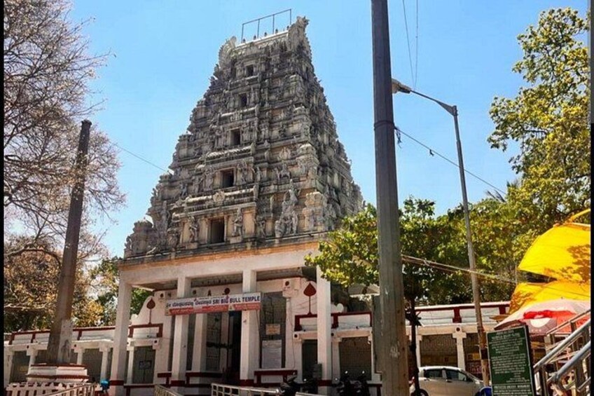 Un templo con un gopuram escalonado, un cartel y una farola. 2