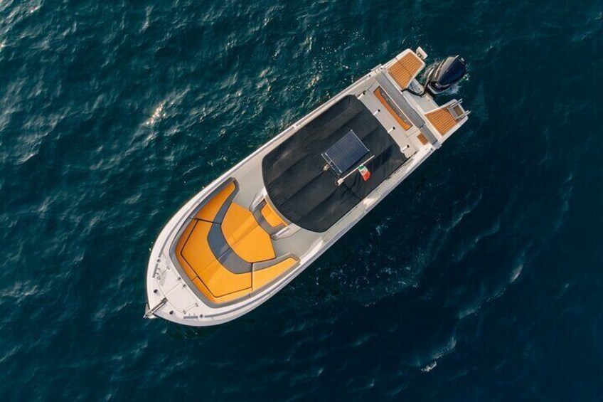 An aerial view of a small motorboat with a yellow and black seating area, a motor at the stern, and a cabin at the rear. 3