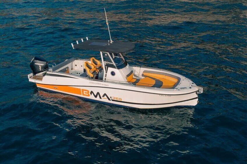 A white and orange motorboat with a cabin and a canopy, floating on water. 2
