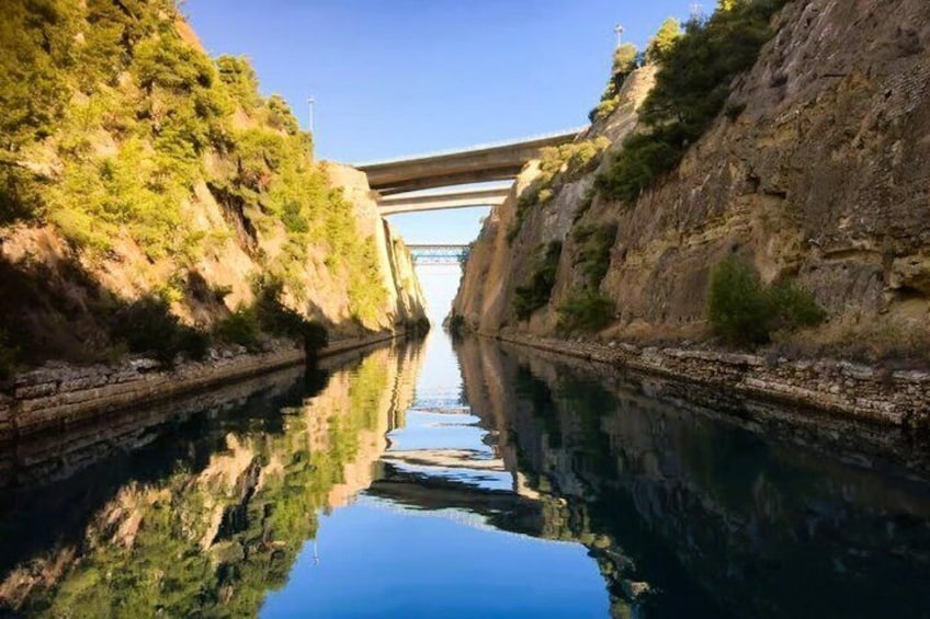 A river reflecting a bridge, with rocky cliffs on either side. 1