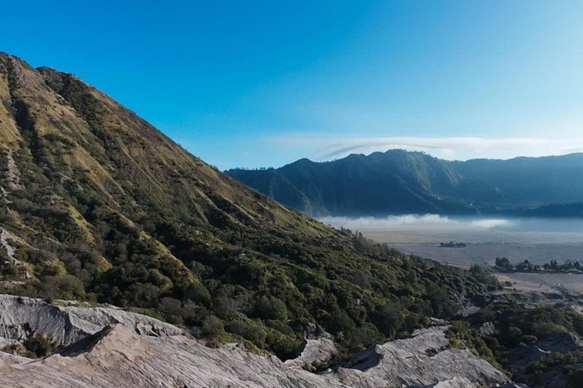 A mountainous landscape with a valley and a body of water. 5