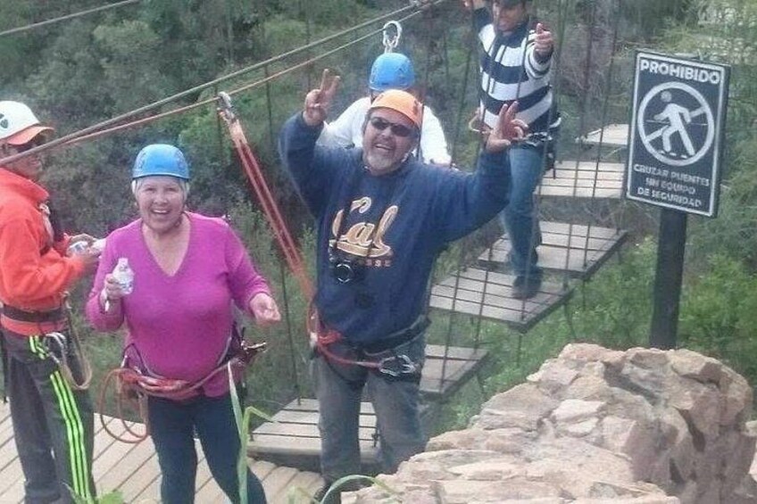 People on a zip line, a sign prohibiting climbing, and a rocky terrain. 2