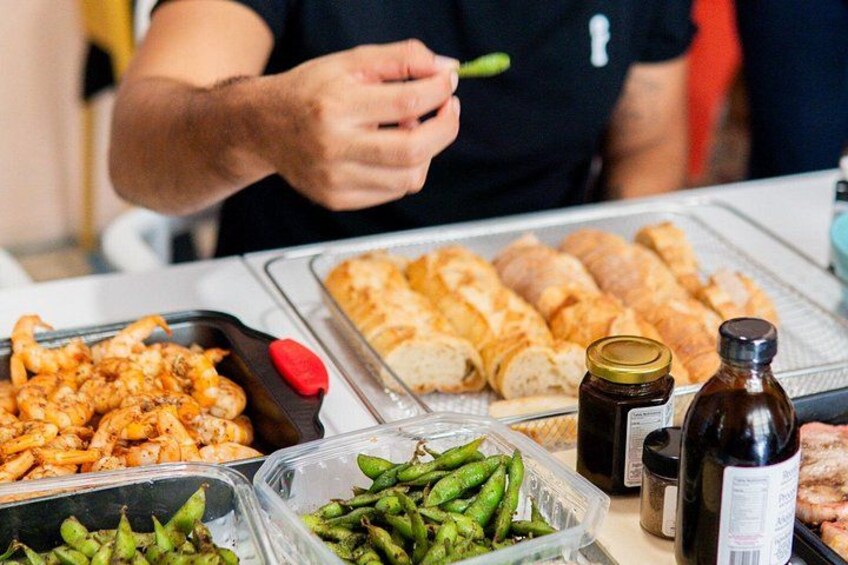 Un puesto de comida con camarones, panecillos, judías verdes y salsas. 5