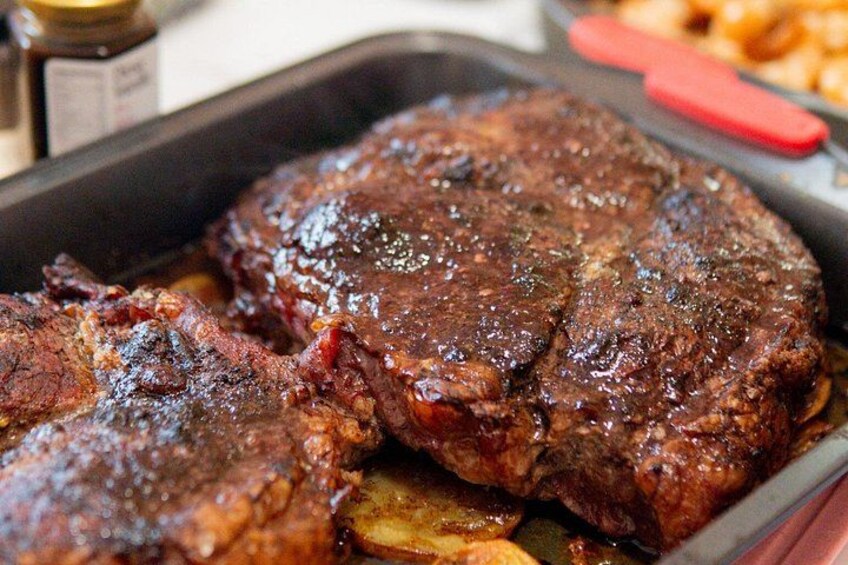Un bistec a la parrilla con marcas visibles y una sartén. 1