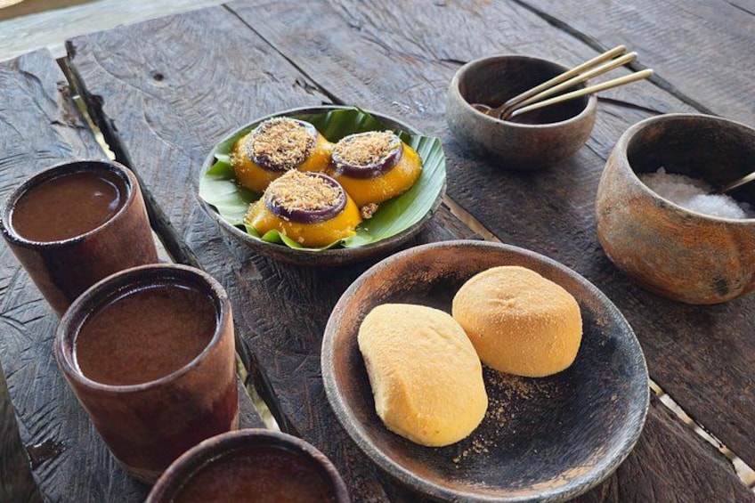 A rustic wooden table with a plate of food, bowls, and cups. 5
