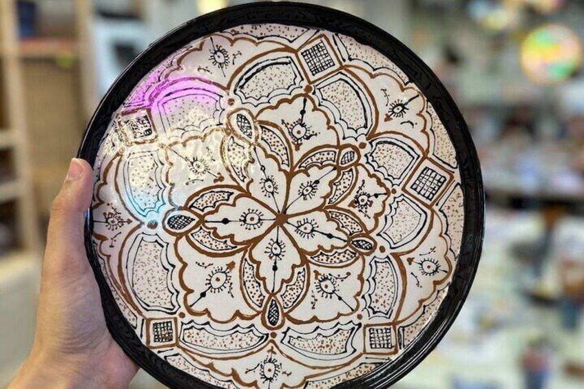 A hand holding a circular object with intricate patterns. 5