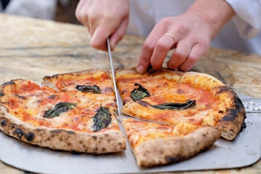A person cutting a pizza with a knife. 1