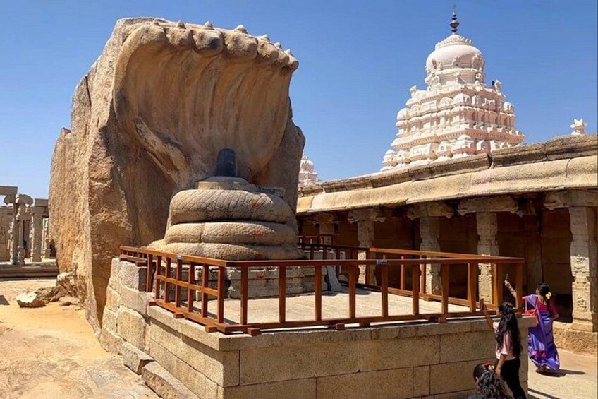 A large rock formation, a temple with a tiered tower, and a person in traditional attire. 5