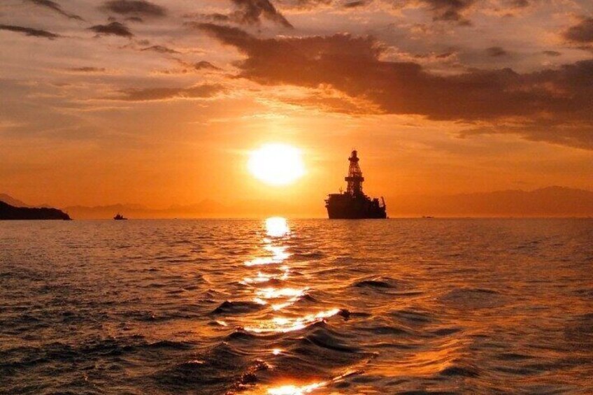 Ein Sonnenuntergang über dem Meer mit einem Schiff in der Ferne. 1