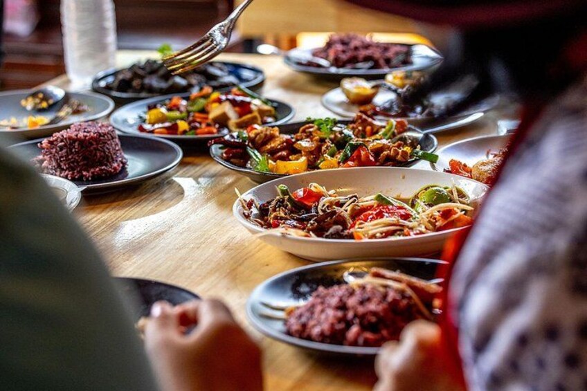 A table with various dishes, including red rice and a vegetable stir-fry. 5