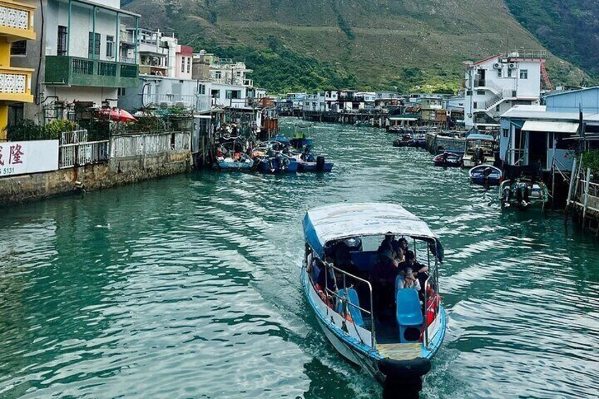 A boat navigating a narrow waterway with buildings on either side. 1