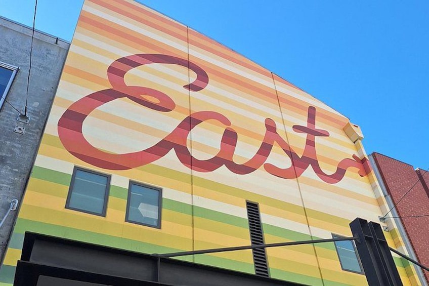A building with a colorful mural featuring the word 'Easts' in large letters. 3