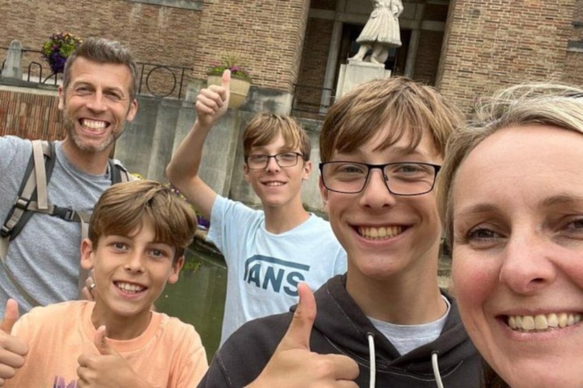 A group of people in front of a brick building with a statue. 5