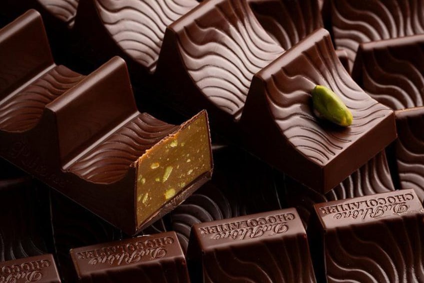 A collection of chocolate bars with a wavy pattern and a green nut on one. 1
