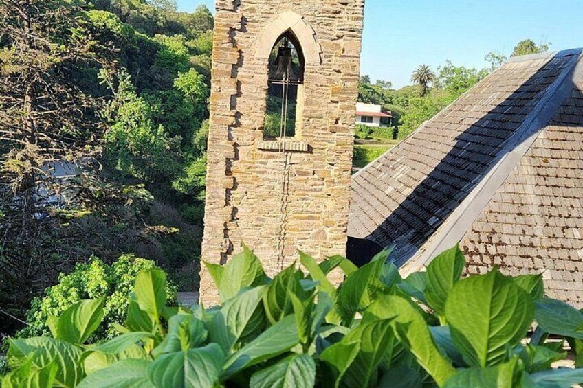 A stone tower with a window, surrounded by greenery. 5
