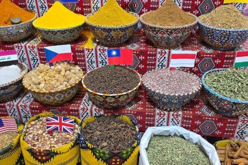 Diversas especias y granos expuestos en cuencos y sacos, con banderas que representan diferentes países. 4