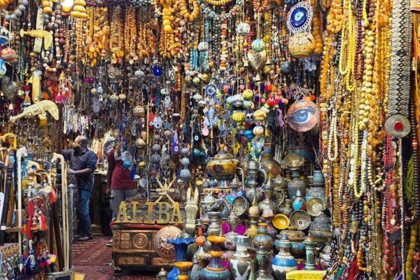 Un puesto de mercado con diversas cuentas, adornos y objetos de metal de colores. 2