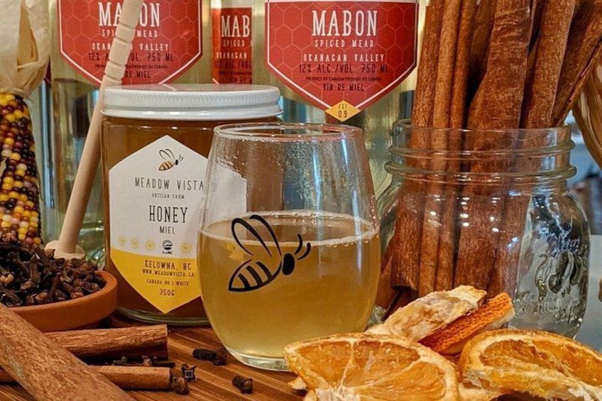 Jars of honey, cinnamon sticks, dried orange slices, and a glass of honey mead. 5