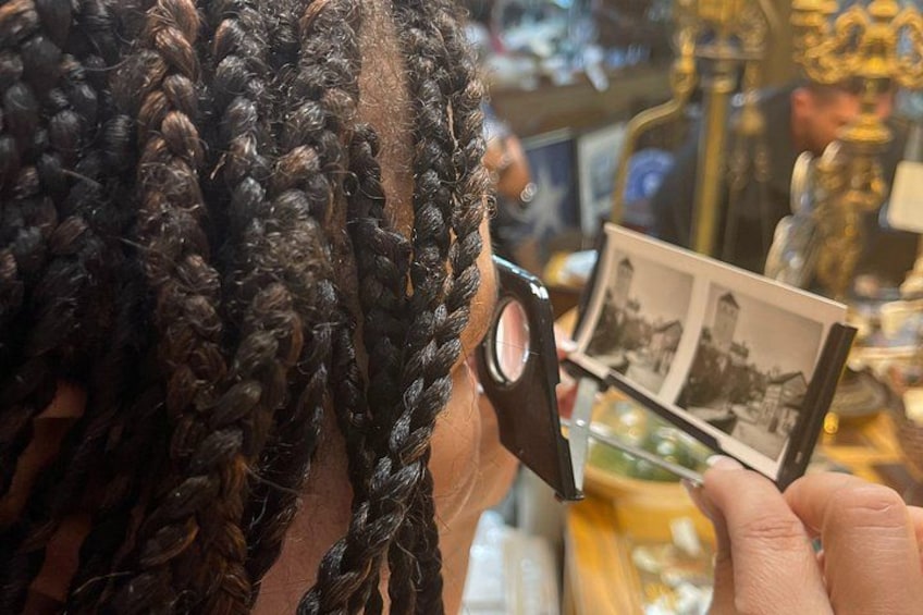 A person cutting hair with scissors, holding a photograph. 1