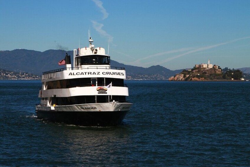 Ein Boot namens 'ALCATRAZ CRUISES' auf dem Wasser, mit einer gebirgigen Landschaft im Hintergrund. 2