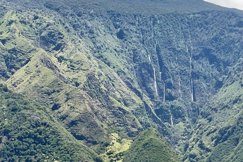 Paesaggio montuoso con fitta vegetazione e un fiume o un corso d'acqua visibile. 4