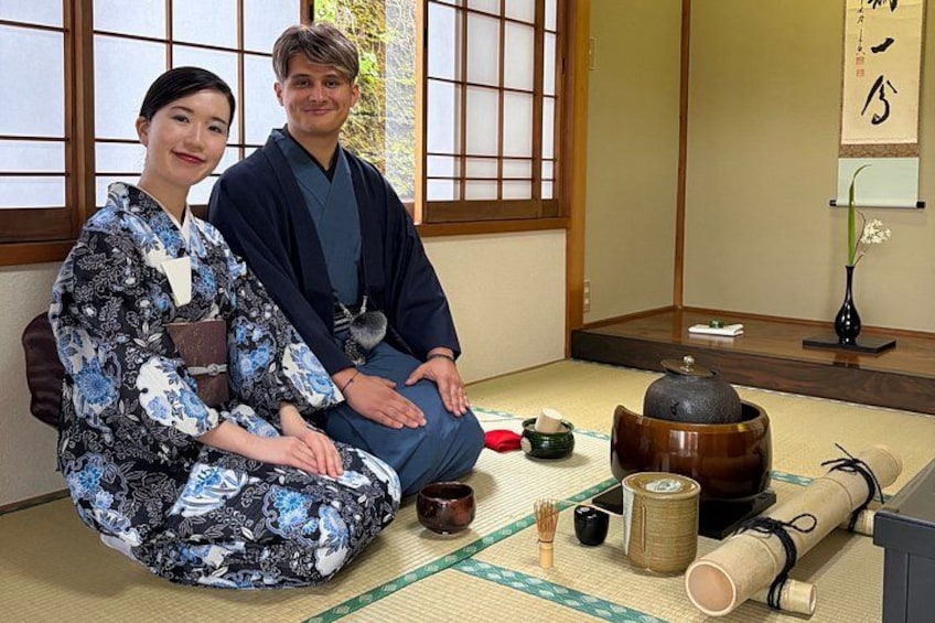 A traditional Japanese room with tatami flooring, a shoji screen, and a tea ceremony setup. 1