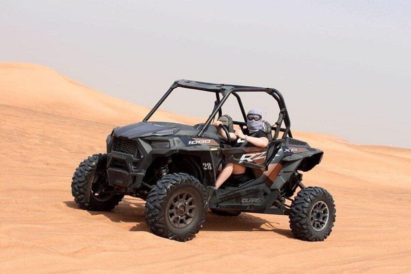 A black off-road vehicle on a sandy terrain. 5