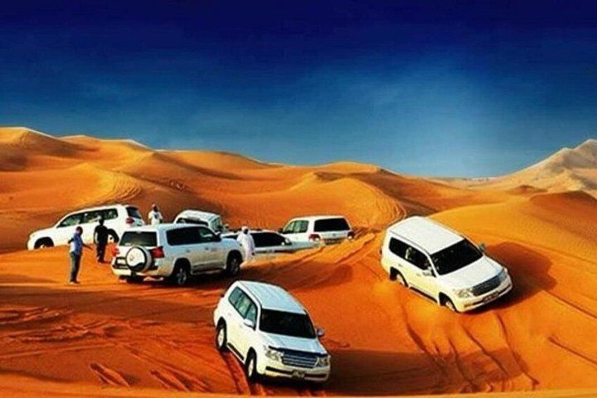 A desert landscape with white vehicles and people. 1