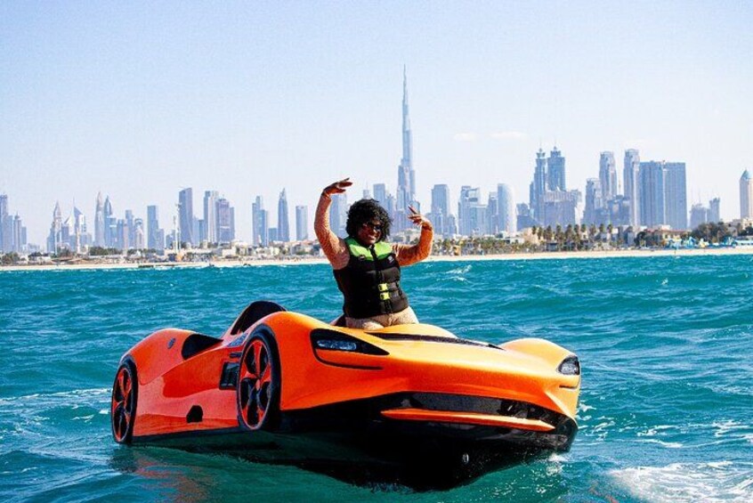 A person on a watercraft with a city skyline in the background. 2