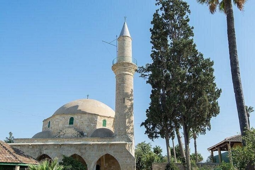 A mosque with a dome and a minaret, surrounded by trees and a clear sky. 3