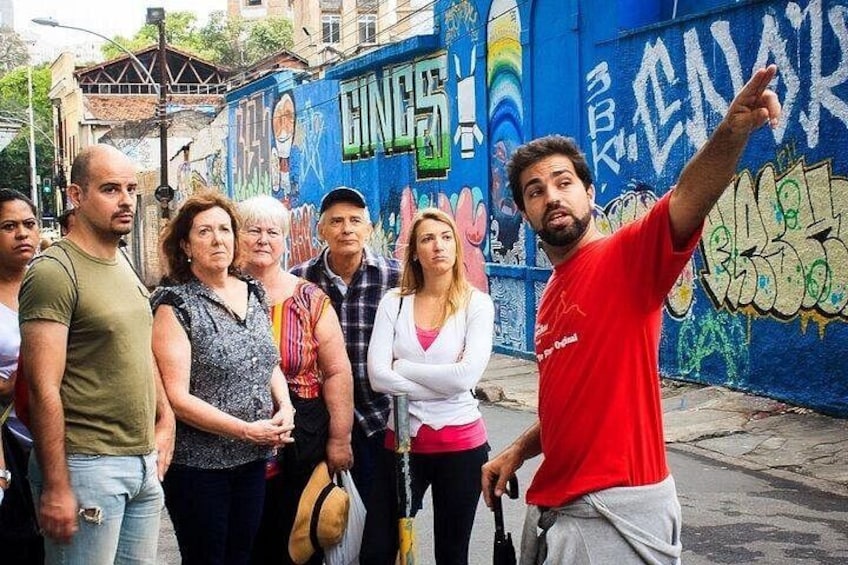 A group of people standing in front of a graffiti-covered wall with the word 'CINEMA' visible. 5