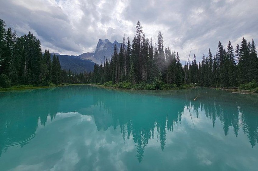 A turquoise lake surrounded by dense forest and mountains. 3