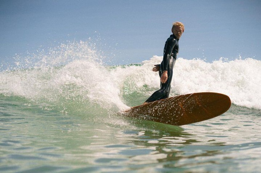 A person surfing on a wave in the ocean. 4