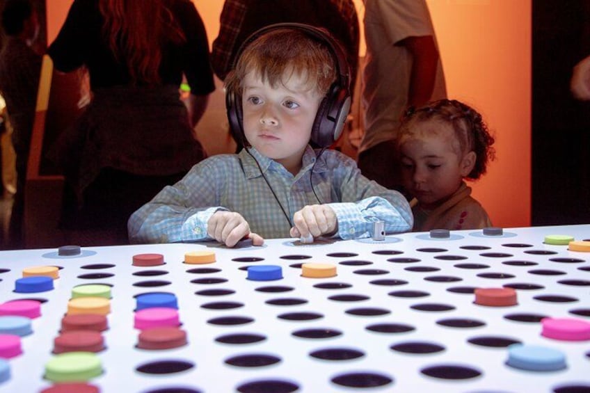 A child playing a game with colorful discs on a table. 4