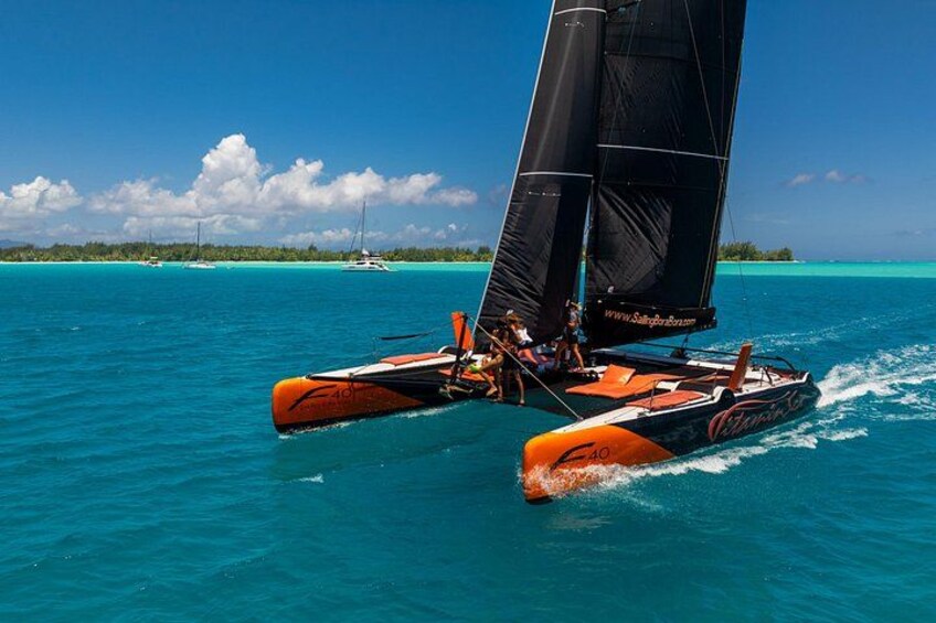 A catamaran sailing on turquoise waters with a clear sky and distant islands. 1