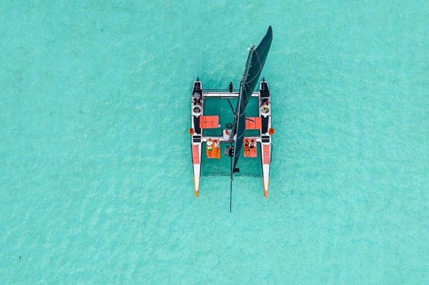 A small boat with a canopy, anchored in clear turquoise water. 2
