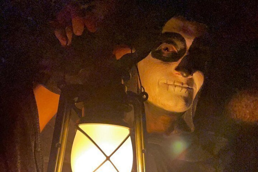 Una persona sosteniendo un farol con un diseño de cruz en el vidrio. 1