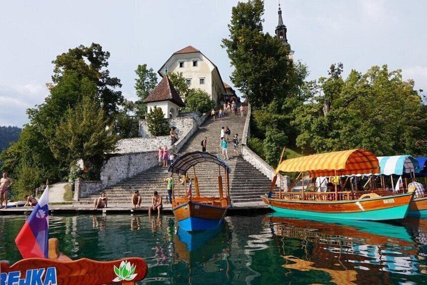 A historic building with a staircase, boats, and a flag. 5