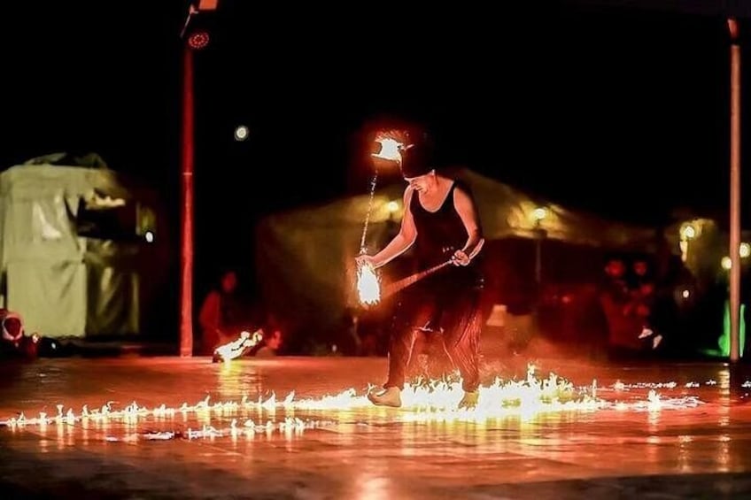 A person performing fire tricks on a street at night. 2