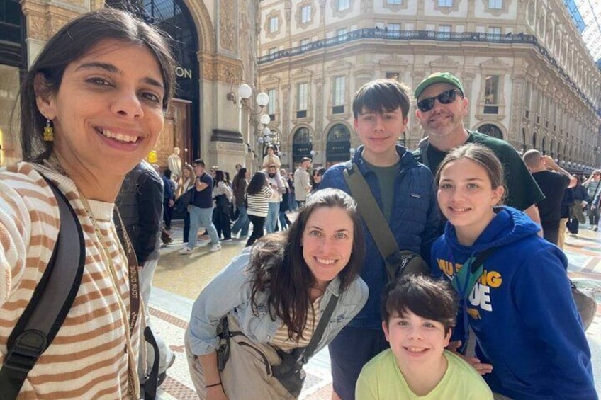 A group of people posing in front of a historic building with ornate architecture. 2