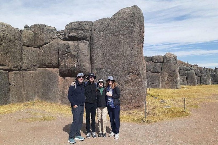 A group of people standing in front of large stone structures. 2