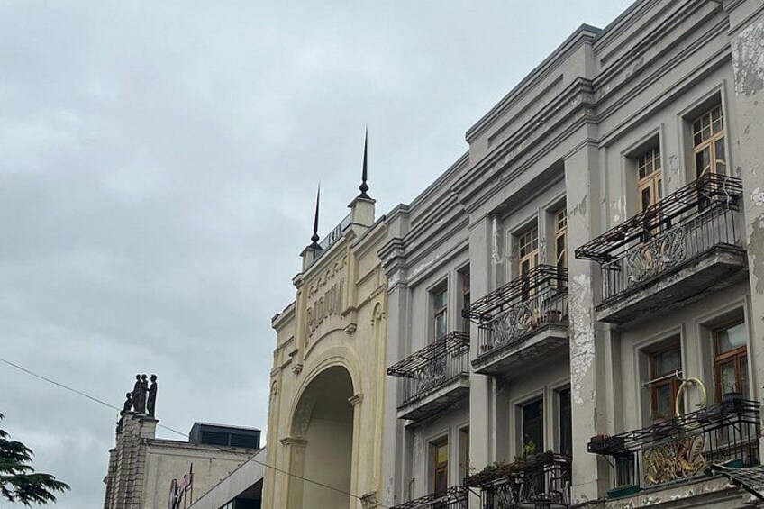 Ein historisches Gebäude mit aufwendigen Balkonen und einem markanten Bogen. 3