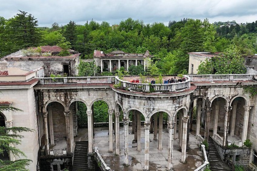 An ancient stone structure with arches and a balcony overlooking a courtyard. 1